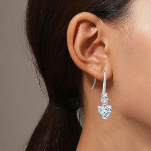 a close up of a person wearing a pair of earrings