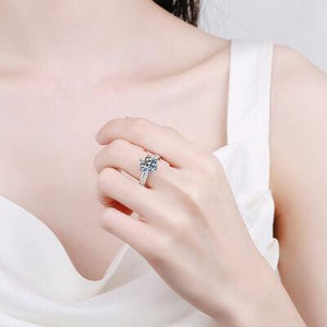 a woman in a white dress holding a ring