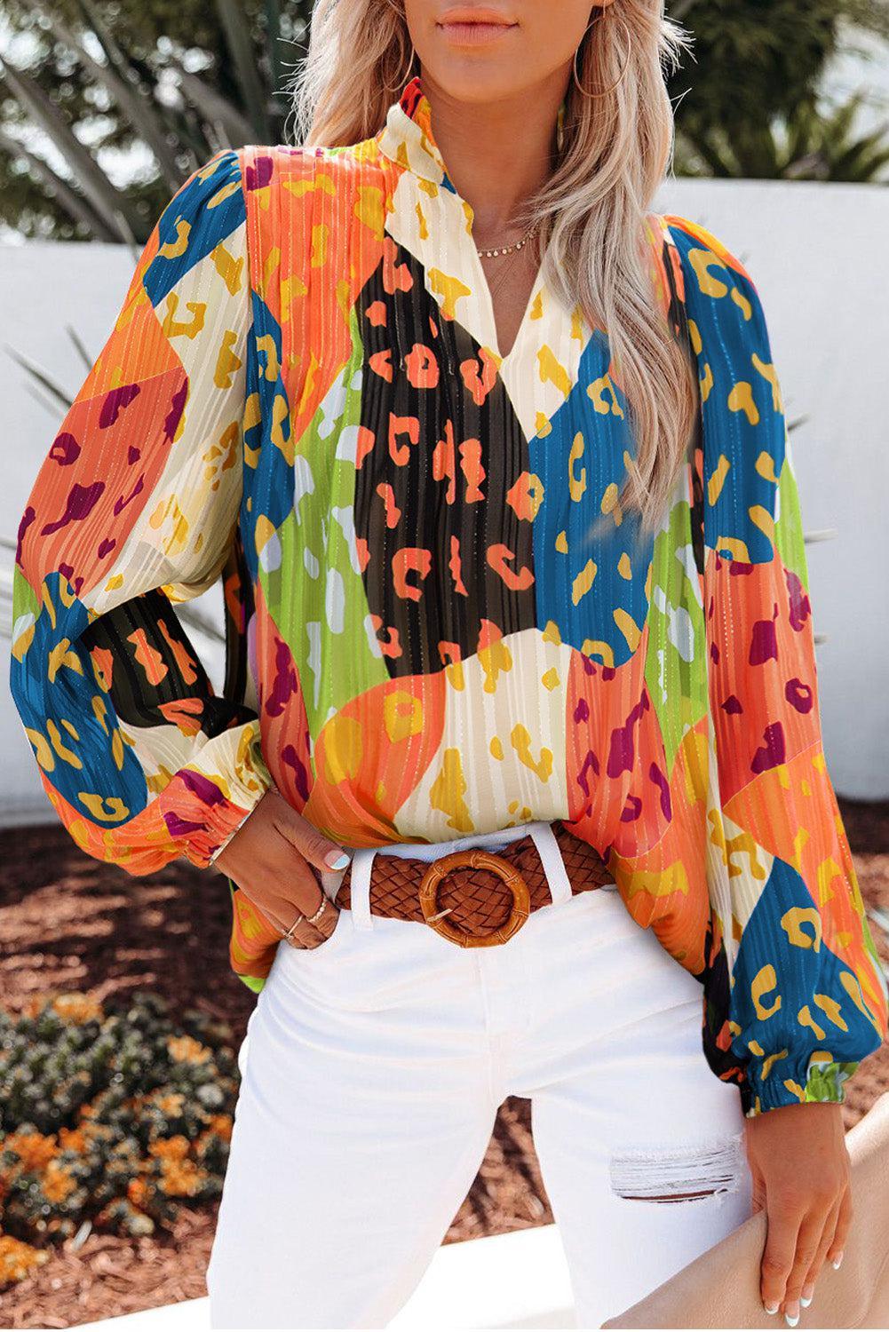 a woman wearing a colorful shirt and white jeans