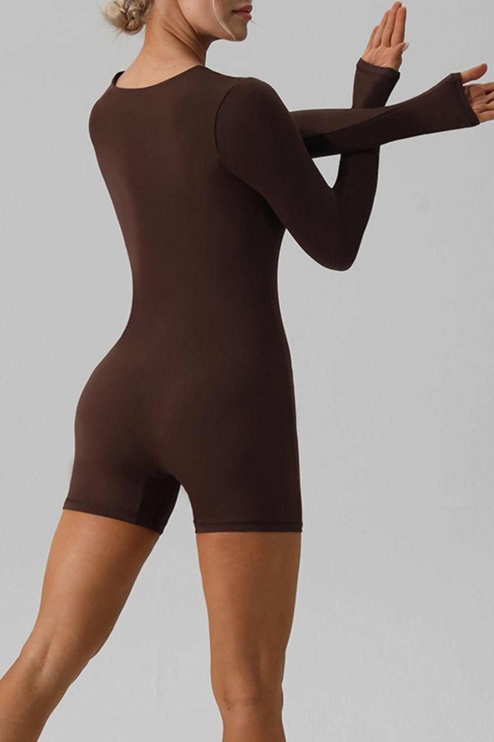 a woman in a brown bodysuit posing for a picture