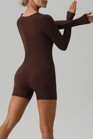 a woman in a brown bodysuit posing for a picture