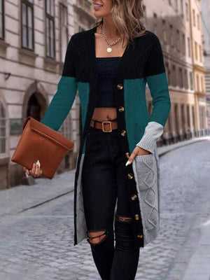 a woman walking down a street wearing a black and green cardigan