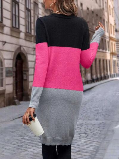 a woman walking down a street wearing a pink and black sweater