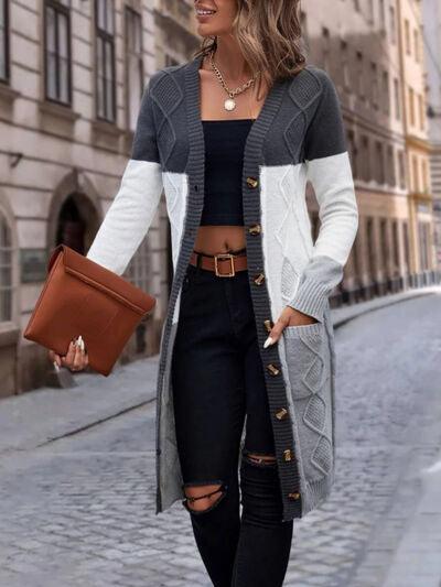 a woman in black jeans and a white and grey cardigan