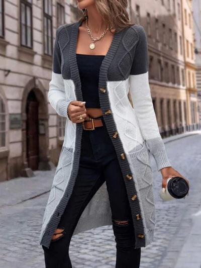 a woman wearing a long cardigan sweater and ripped jeans