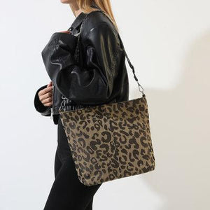 a woman carrying a leopard print purse