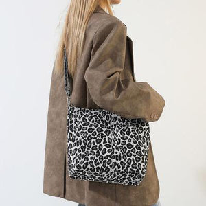 a woman carrying a leopard print purse