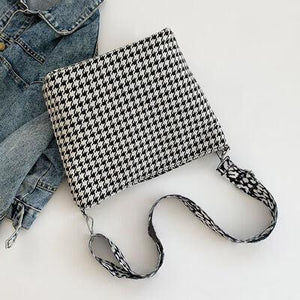 a purse sitting on top of a pair of jeans