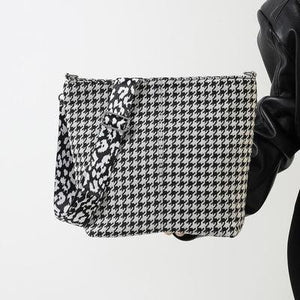 a woman is holding a black and white bag