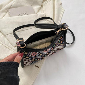 a woman is holding a small black purse