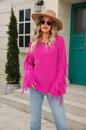 a woman wearing a pink sweater and jeans