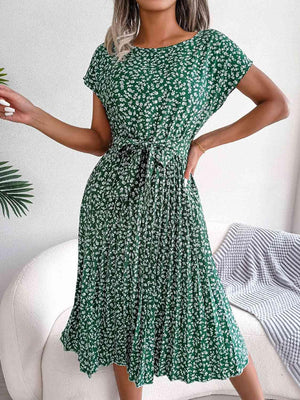 a woman wearing a green floral print dress