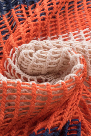 a close up of an orange and blue knitted blanket
