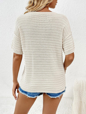 a woman wearing a white sweater and denim shorts