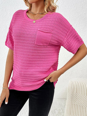 a woman wearing a pink top with a pocket