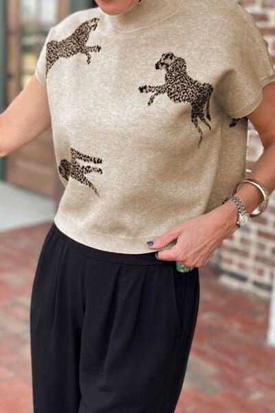 a woman wearing a sweater with horses on it