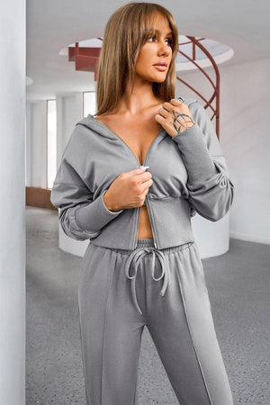 a woman in a grey outfit posing for a picture