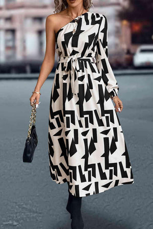 a woman in a black and white dress is walking down the street
