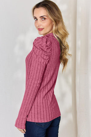 a woman wearing a pink sweater and jeans