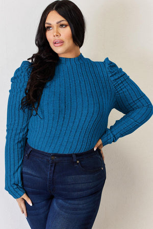 a woman in a blue sweater poses for a picture