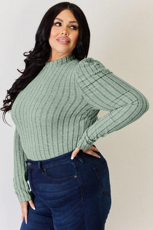 a woman in a green sweater posing for a picture