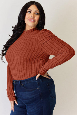 a woman wearing a brown sweater and jeans