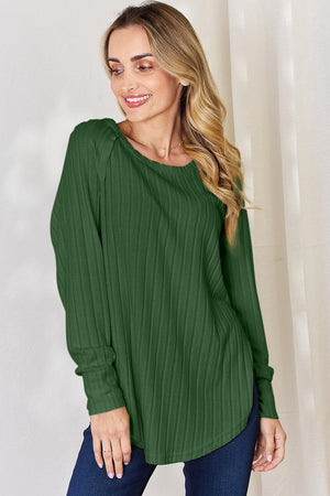 a woman wearing a green top and jeans