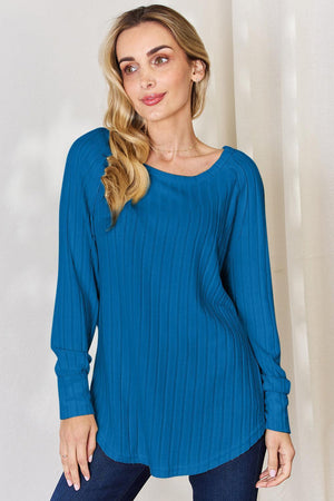 a woman in a blue top poses for a picture