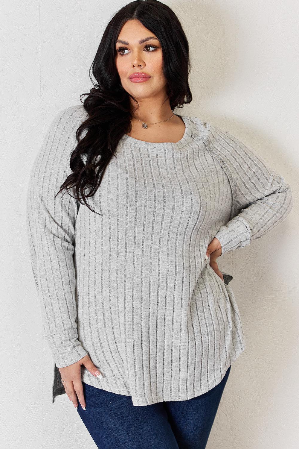a woman wearing a gray sweater and jeans