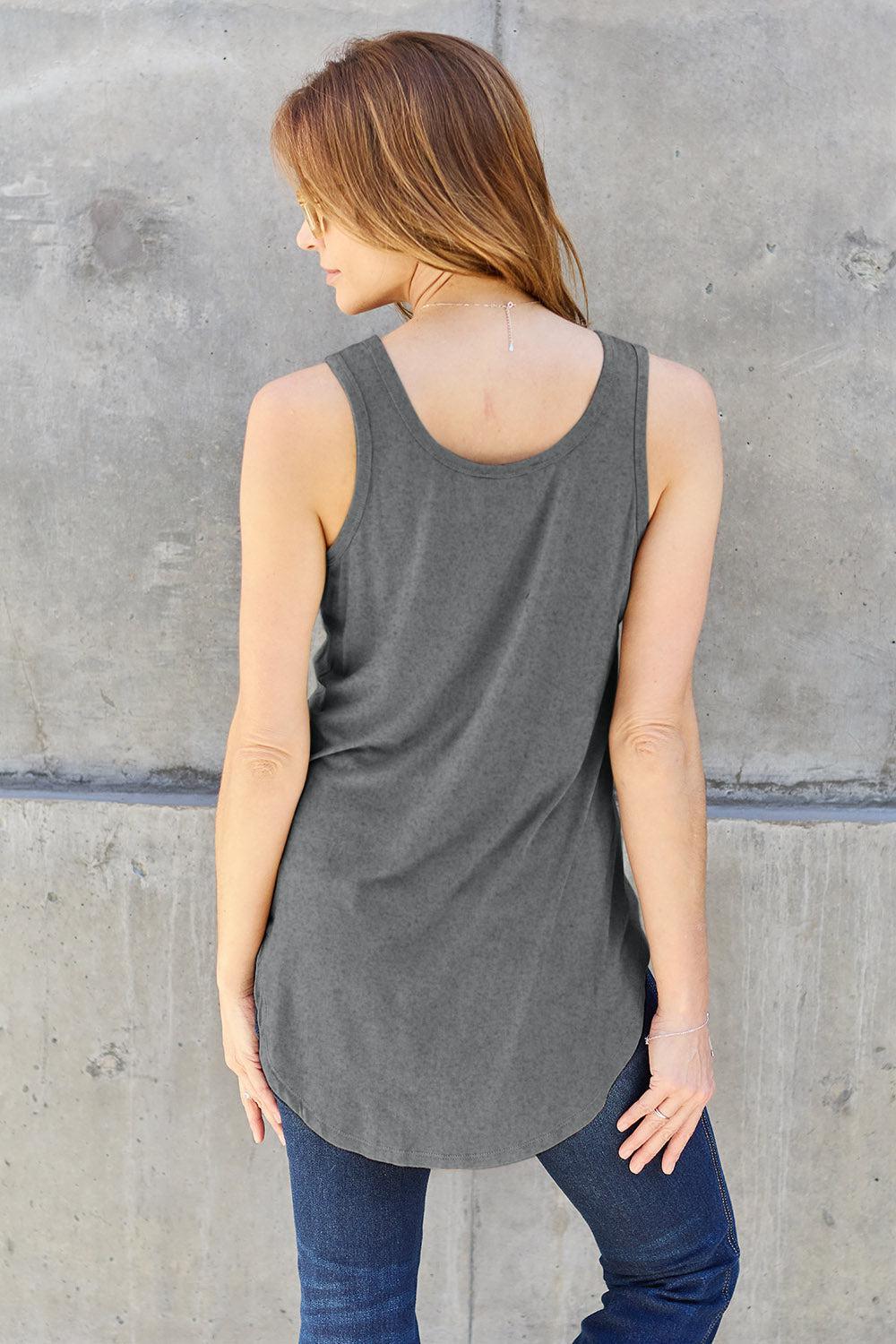 a woman standing in front of a concrete wall