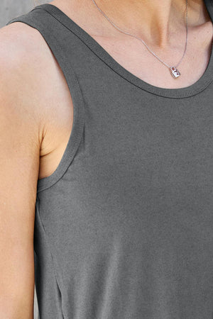 a woman wearing a gray tank top and a silver necklace