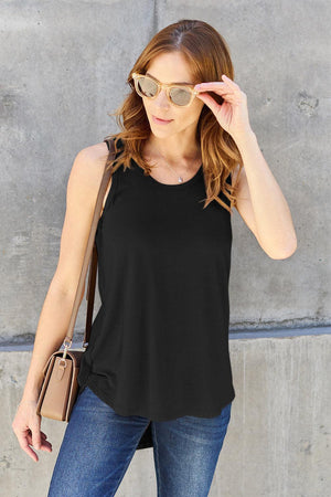 a woman wearing a black tank top and jeans