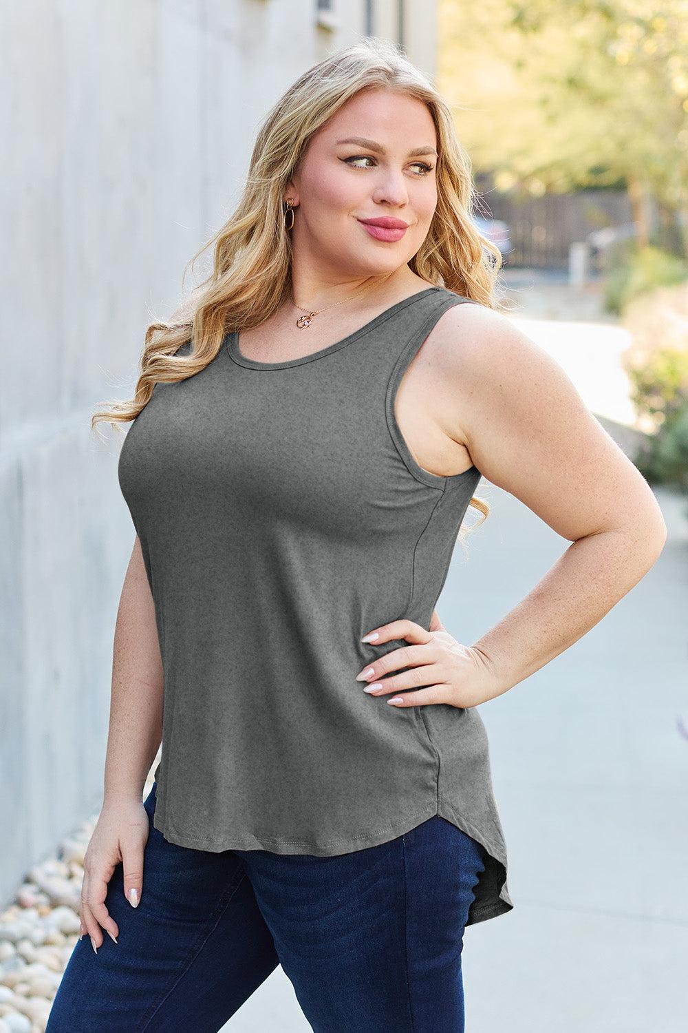 a woman posing for a picture while wearing a tank top