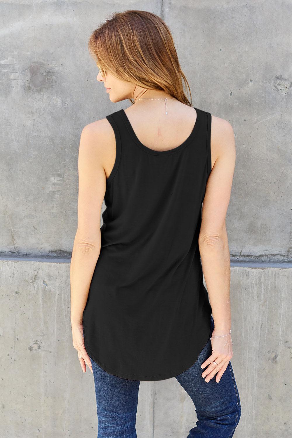 a woman standing in front of a concrete wall