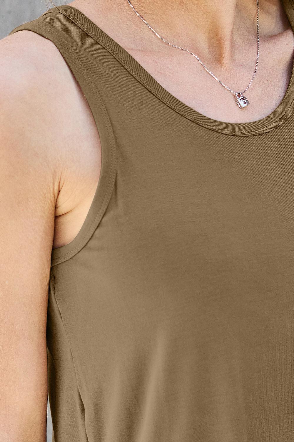 a woman wearing a brown tank top and a necklace