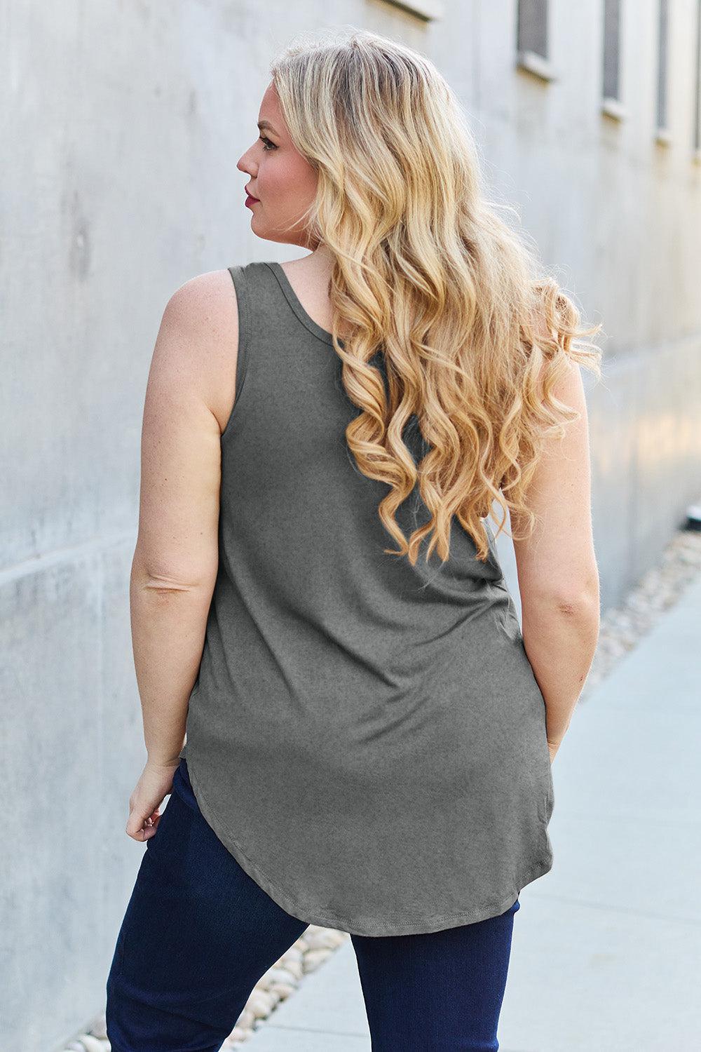 a woman standing on a sidewalk with her back to the camera