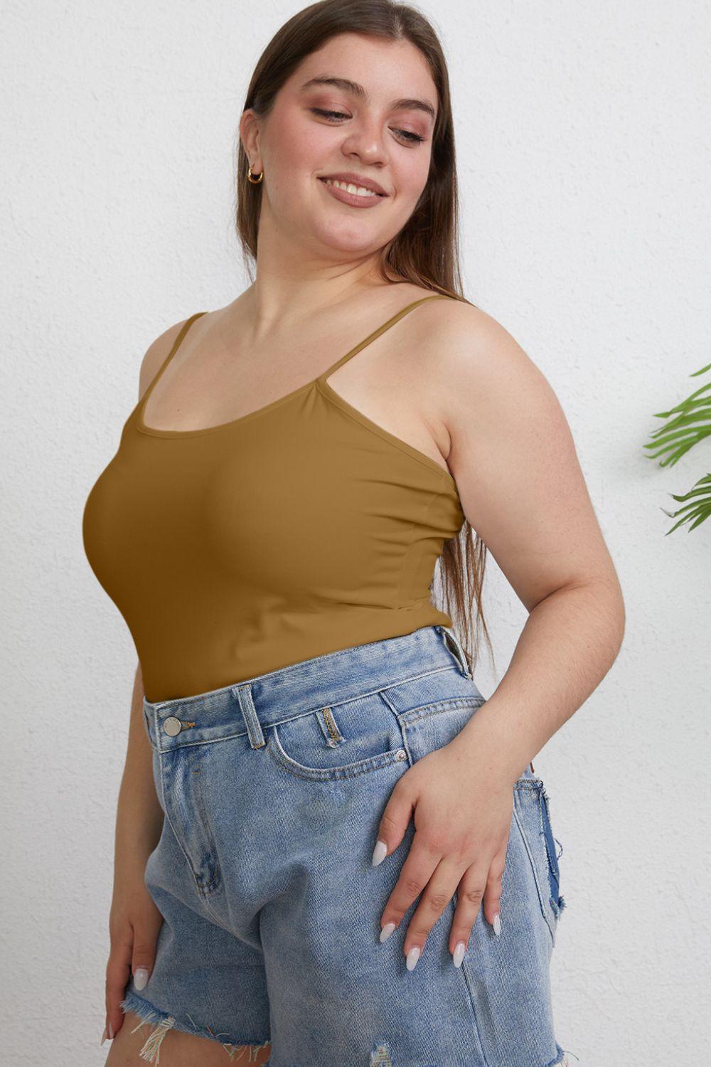 a woman in a tan tank top is posing for the camera