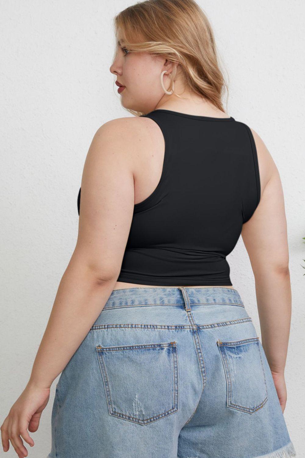 a woman in a black tank top and jean shorts