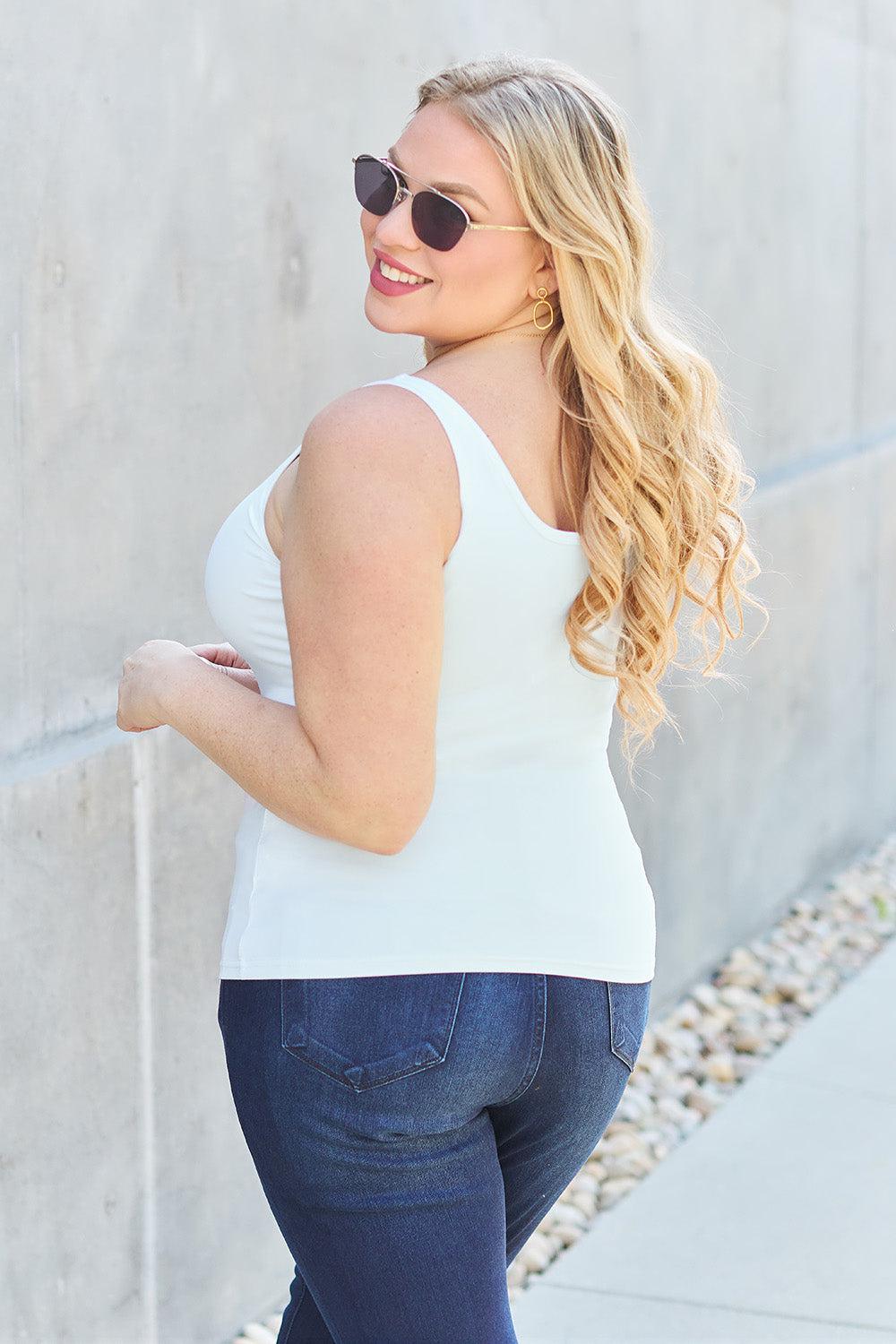 a woman wearing a white top and jeans