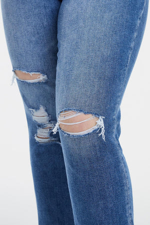 a woman in ripped jeans with a cell phone in her hand