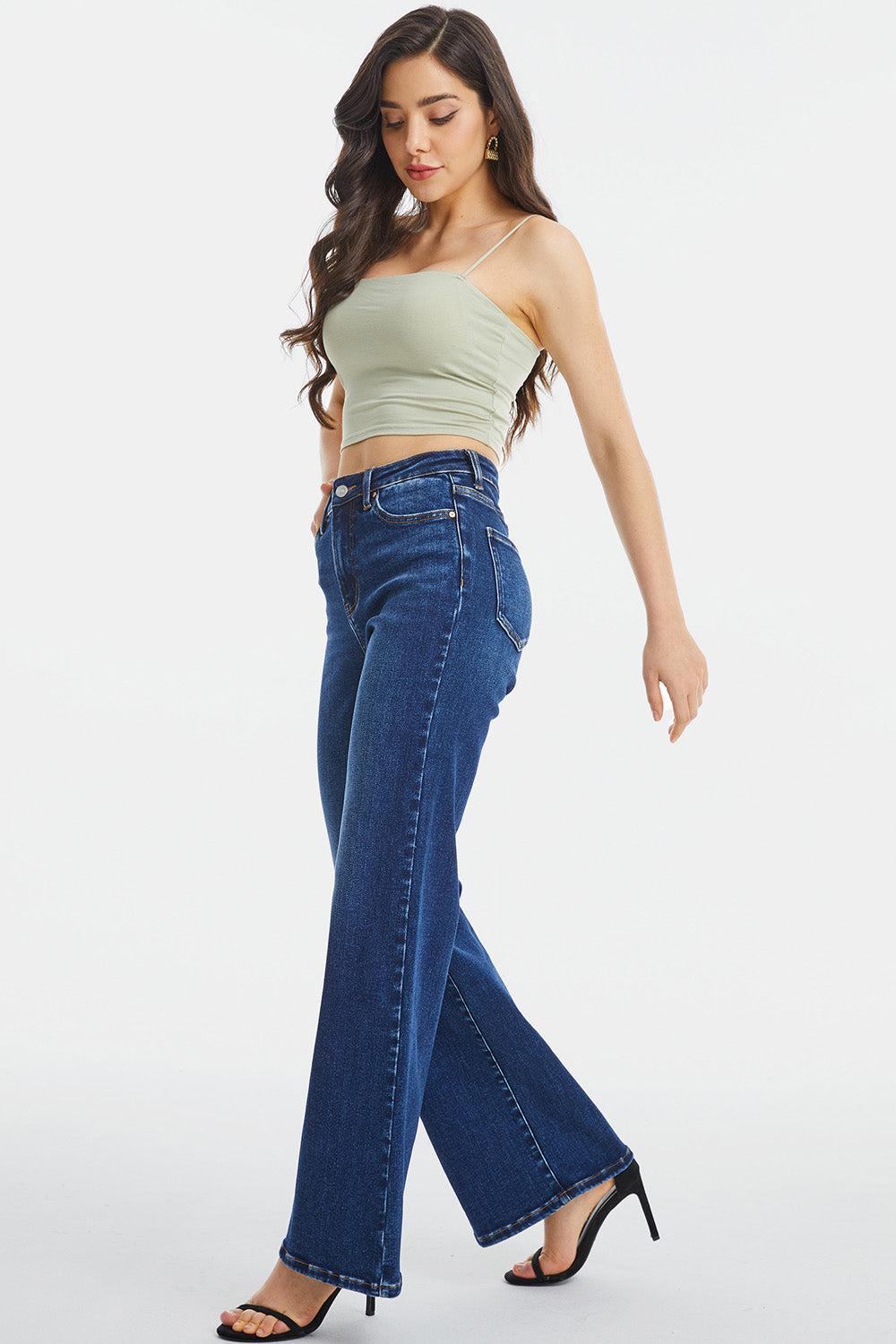 a woman wearing high rise jeans and a crop top