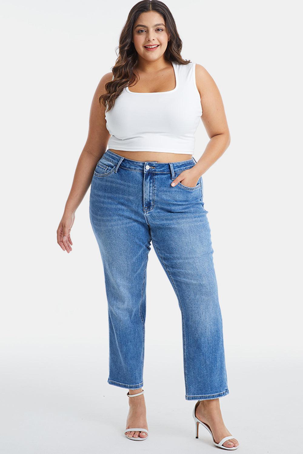 a woman wearing high rise jeans and a white tank top