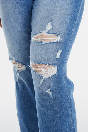 a woman in ripped jeans with a cell phone in her hand