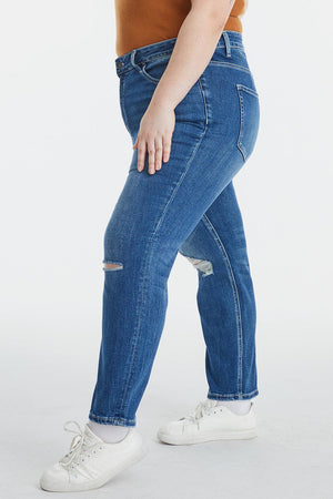 a woman in a brown shirt and blue jeans