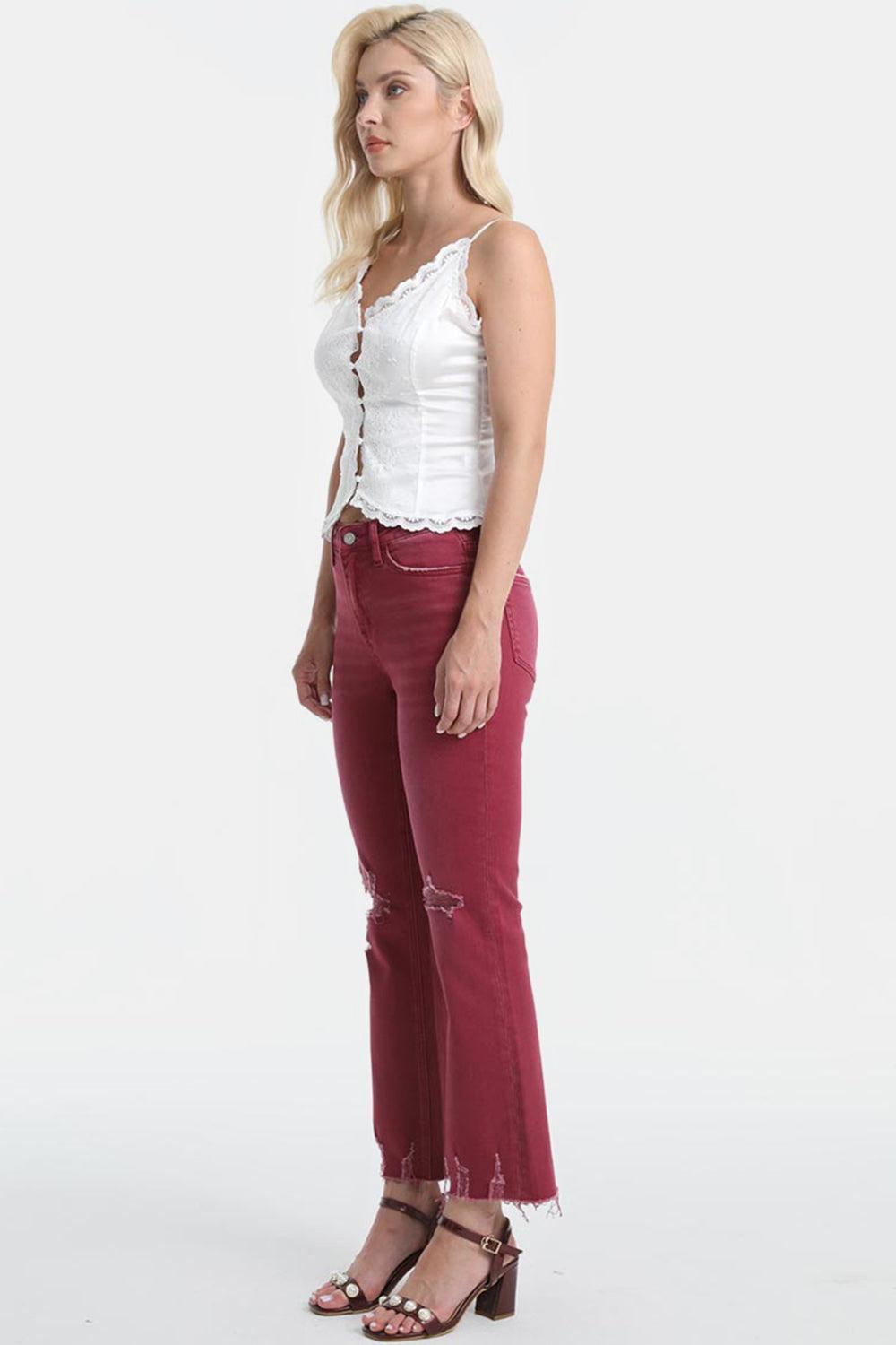 a woman in a white top and red jeans