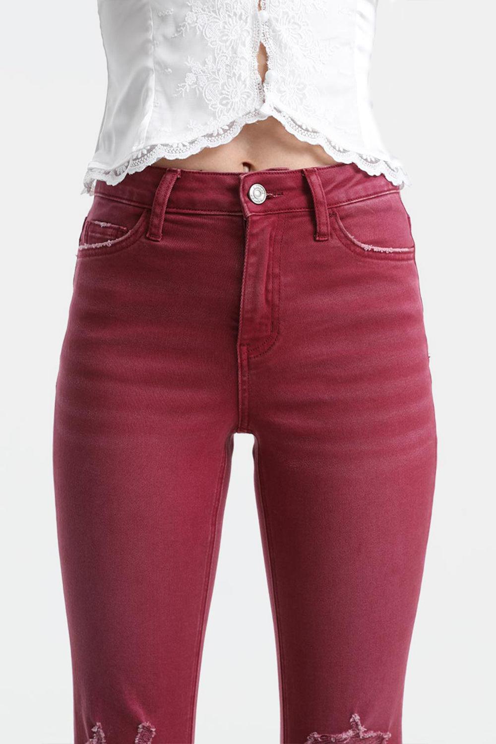 a woman wearing red jeans and a white top