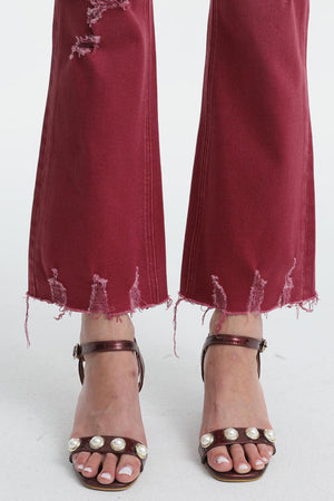 a woman's feet with a pair of red jeans
