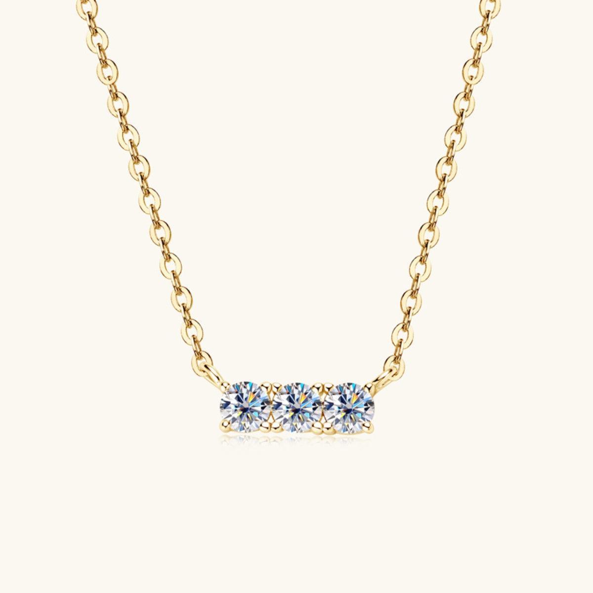 a gold necklace with three blue stones on it