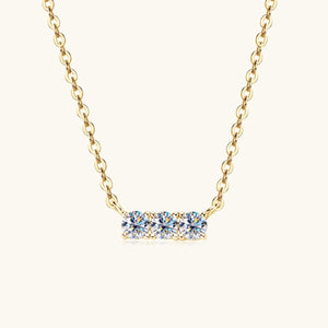 a gold necklace with three blue stones on it