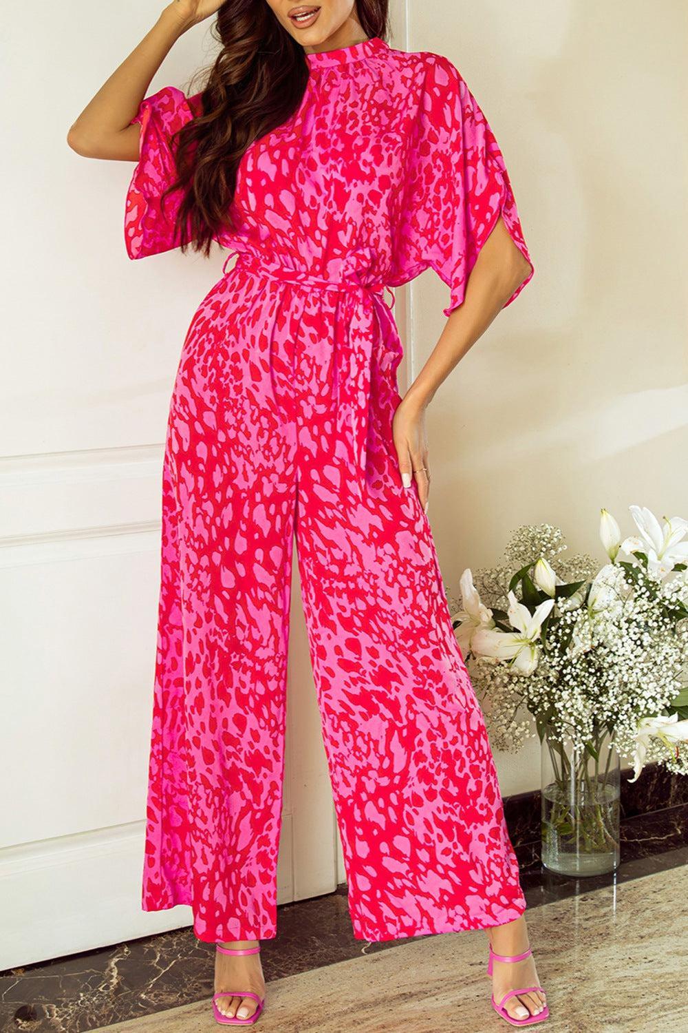 a woman in a pink jumpsuit posing for a picture